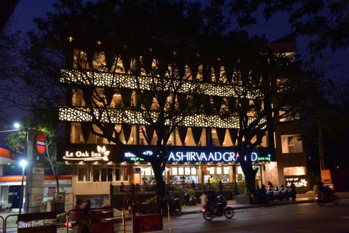 a building with a tree in front of it at night at Le Oak Inn in Mysore