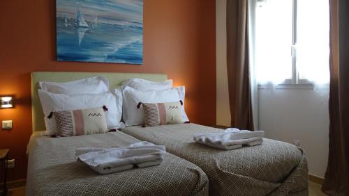 sypialnia z 2 łóżkami i ręcznikami w obiekcie Résidence Casa Régina w mieście Propriano