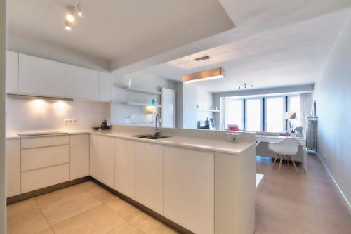 a large white kitchen with a sink and a table at Sea View in Ostend