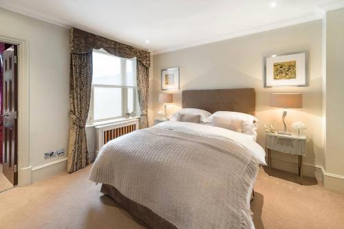 Un dormitorio con una cama grande y una ventana en Grand Ambassadorial Duplex Apartment Hyde Park, en Londres