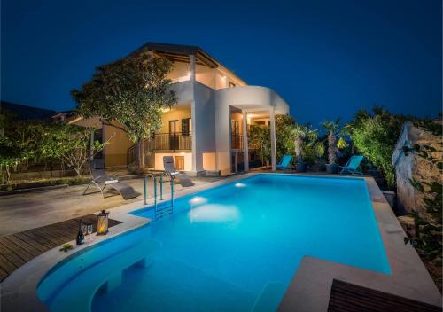 a swimming pool in front of a house at night at Villa Didovi dvori in Marina