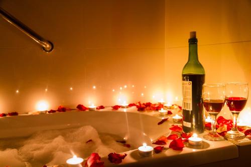 a bottle of wine and candles in a bath tub at Eurotel Vivaldi Araneta in Manila