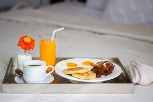a tray with a plate of breakfast food and a cup of coffee at Eurotel Vivaldi Araneta in Manila