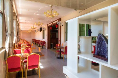 a dining room with red chairs and tables in a restaurant at Riverside Hotel in Portsmouth