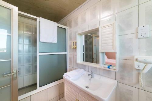 a white bathroom with a sink and a mirror at Riverside Hotel in Portsmouth
