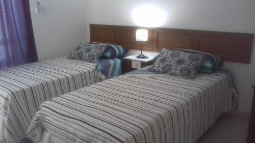 a hotel room with two beds and a lamp at El Balcón 2 in Concepción del Uruguay