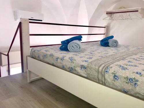 a bedroom with a bed with blue pillows on it at Villetta Natalia 2 in Torre Colimena