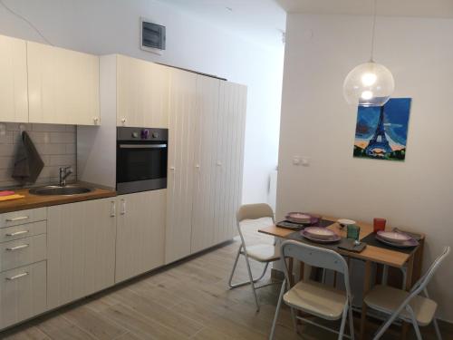 a kitchen with a table and chairs and a kitchen with a sink at Apartman Studio Kod Ujevića in Baška Voda