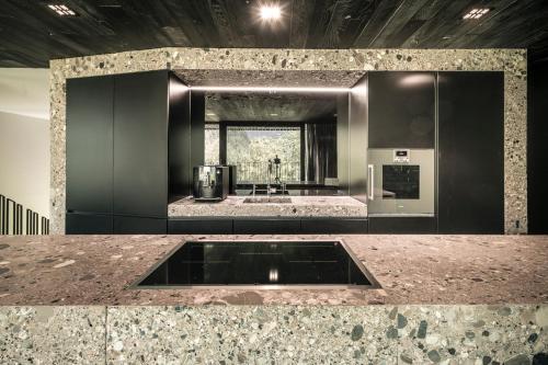 eine Küche mit einem Waschbecken in der Mitte eines Zimmers in der Unterkunft Luxus Chalet Quellhaus in Hinterstoder