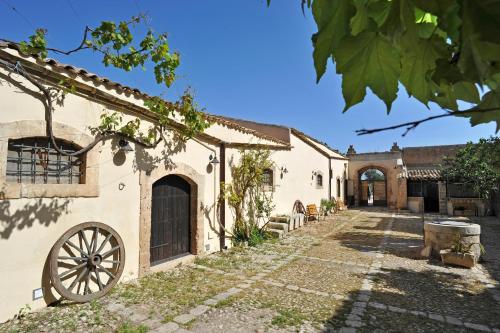 a courtyard of a house with a cannon at Baglio Siciliamo Country House in Noto Marina