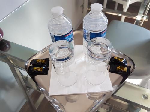 three bottles of water sitting on a glass table at Le Clos Magedon in Médan