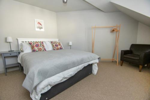 a bedroom with a large bed and a chair at Arundel Mews - Parking - by Brighton Holiday Lets in Brighton & Hove