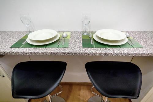 2 Stühle an einem Tisch mit Tellern und Servietten in der Unterkunft Útulný druhý domov v srdci Žiliny in Žilina