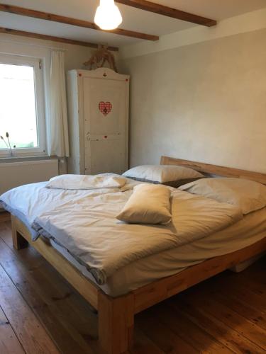 a large bed in a bedroom with a window at Landhausidylle in Naturparknähe in Rum Kogel