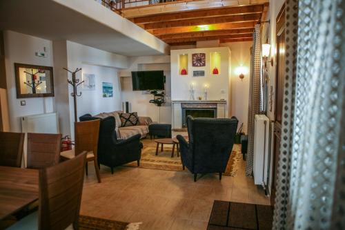 a living room with a couch and chairs and a fireplace at Pacithea Villas in Miléai
