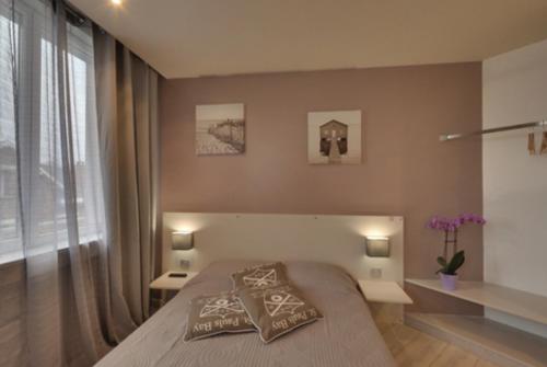 a bedroom with a bed with two pillows on it at La Caroline in Corbie