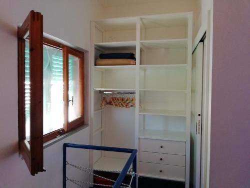 a walk in closet with a window and a shelf at Rosa dei Venti in Procchio