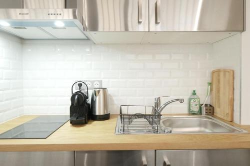 a kitchen counter with a sink and a dish rack at Amazing Comfy Studio - Canal Saint Martin in Paris