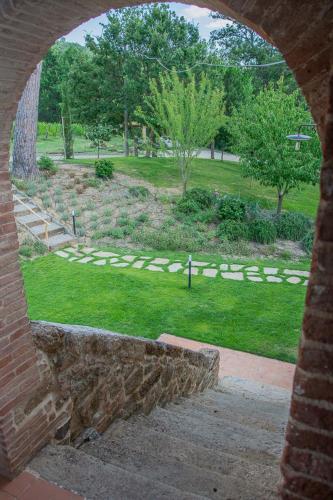 a view of a park through a stone archway at Villa Talosa in Montepulciano