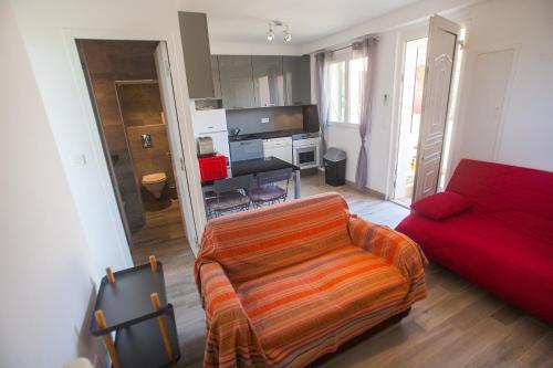 a living room with a couch and a red sofa at Résidence Padro in Calvi
