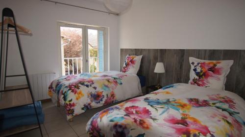 a bedroom with two beds and a window at L'Orchidée à 18 minutes d'Eurexpo in Saint-Laurent-de-Mure