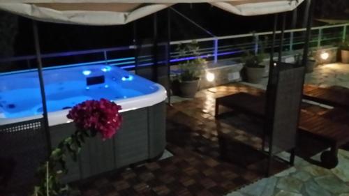 a jacuzzi tub on a balcony at night at Pacithea Villas in Miléai