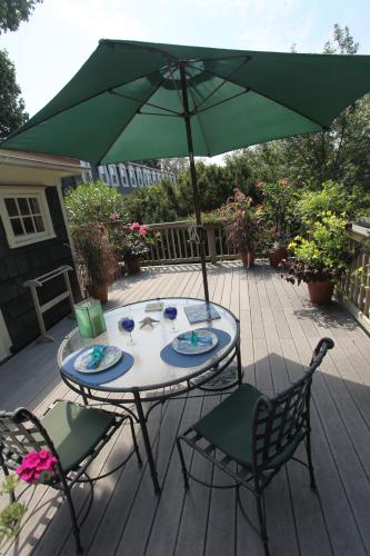 a table and chairs with an umbrella on a patio at Thomas Webster House in Cape May