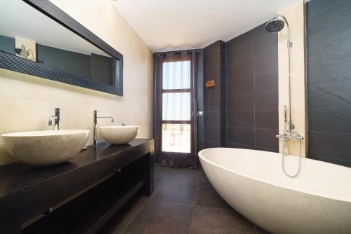 a bathroom with two sinks and a bath tub at Daru Dunya in Beniarbeig