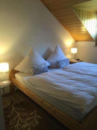 Schlafzimmer mit einem Bett mit weißer Bettwäsche und Kissen in der Unterkunft Haus Mosella in Cochem
