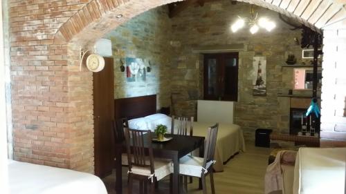 a dining room with a table and a brick wall at Pacithea Villas in Miléai