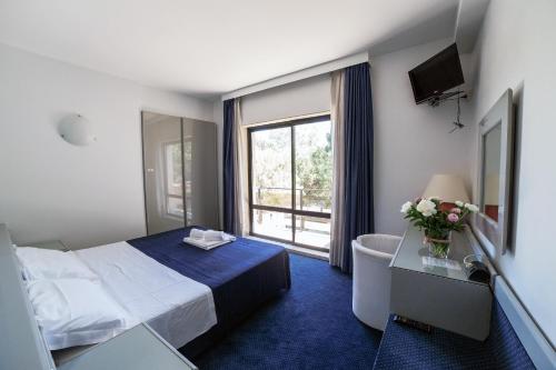 a hotel room with a bed and a window at Club Hotel in Mestre