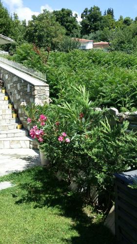 a retaining wall with flowers and plants in a yard at Pacithea Villas in Miléai