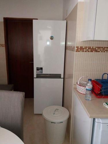 a bathroom with a white toilet in a kitchen at A Minha Casa in Sesimbra