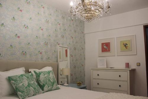 a bedroom with a bed and a chandelier at A Minha Casa in Sesimbra