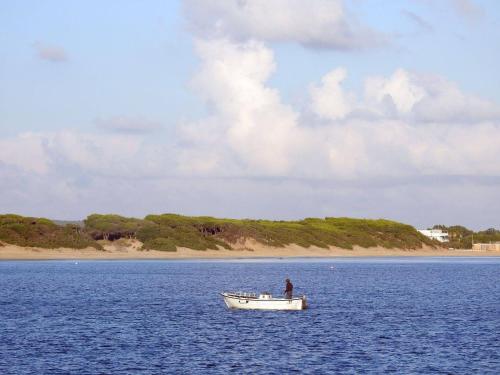 a man in a boat in the middle of the water at Villetta Natalia in Torre Colimena