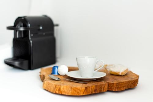 a cup of coffee on a wooden cutting board with a coffee maker at Anamnisi Mykonos in Mýkonos City