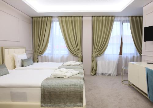 a bedroom with two beds and a tv and curtains at Monte Vedetta in Sliven