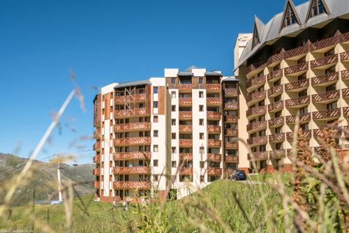 un grand bâtiment avec une voiture garée devant dans l'établissement Résidence Pierre & Vacances Le Machu Pichu, à Val Thorens