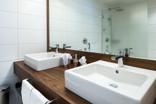 a bathroom with a white sink and a mirror at Superior Hotel Nidwaldnerhof in Beckenried