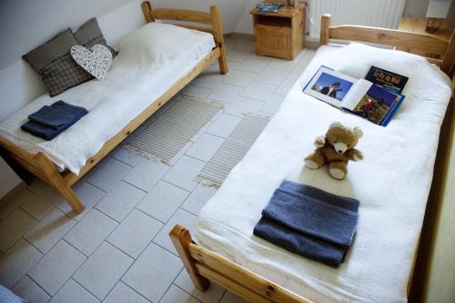 a bed with a teddy bear sitting on it at Gîtes Estives d'Arrens in Arrens-Marsous
