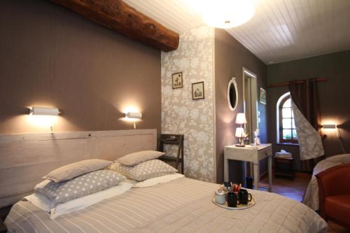 een slaapkamer met een groot bed en een tafel. bij RAND'HÔTES in Les Genettes