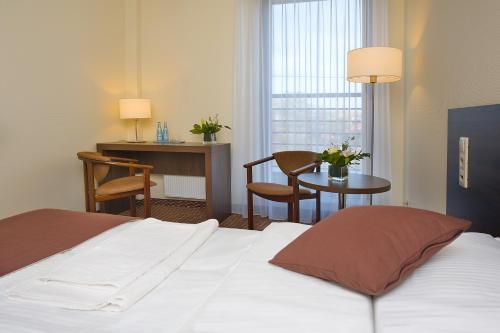 pokój hotelowy z łóżkiem i stołem z krzesłami w obiekcie Hotel Cztery Brzozy Gdańsk Kowale w Gdańsku
