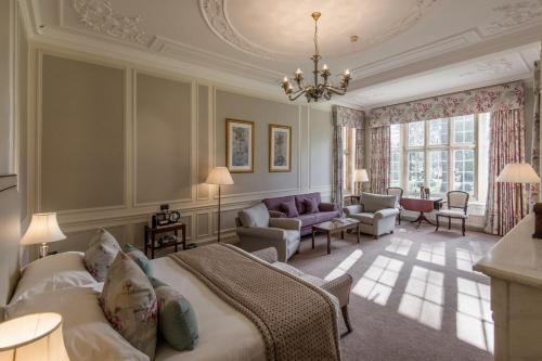 a bedroom with a bed and a living room at Tylney Hall Hotel in Hook