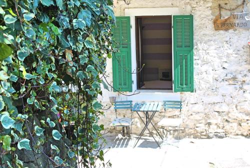 a building with green shutters and a window with chairs at STECADÒ - Camera Lavanda in Dolceacqua