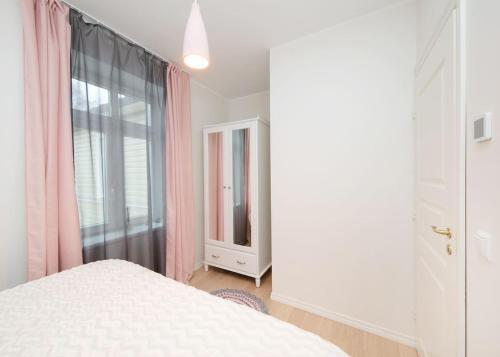 a bedroom with a white bed and a window at Modern quiet 2 bedroom apartment near City center in Pärnu