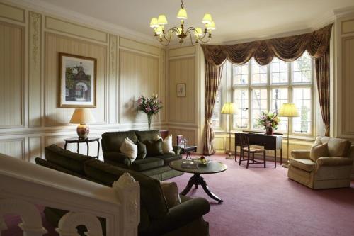 a living room with a couch and a table at Tylney Hall Hotel in Hook
