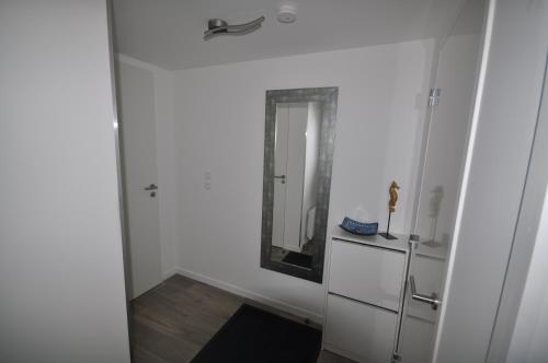a white room with a mirror and a dresser at Dervenn Mor in Sarzeau