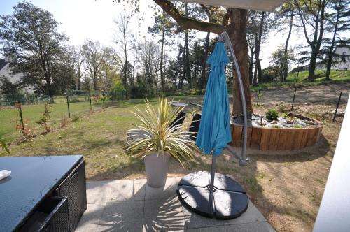 a blue umbrella sitting next to a potted plant at Dervenn Mor in Sarzeau
