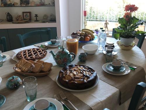 uma mesa com um grande bolo de chocolate e pão em B&B La Palma em San Costanzo