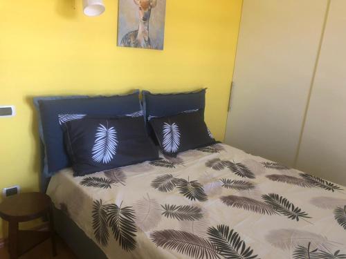 a bedroom with a bed with two blue pillows at B&B La Palma in San Costanzo